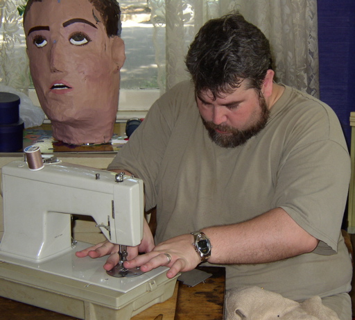 Hoke sews, the Giant Floating Head rolls his eyes