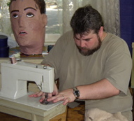 Hoke sews, the Giant Floating Head rolls his eyes